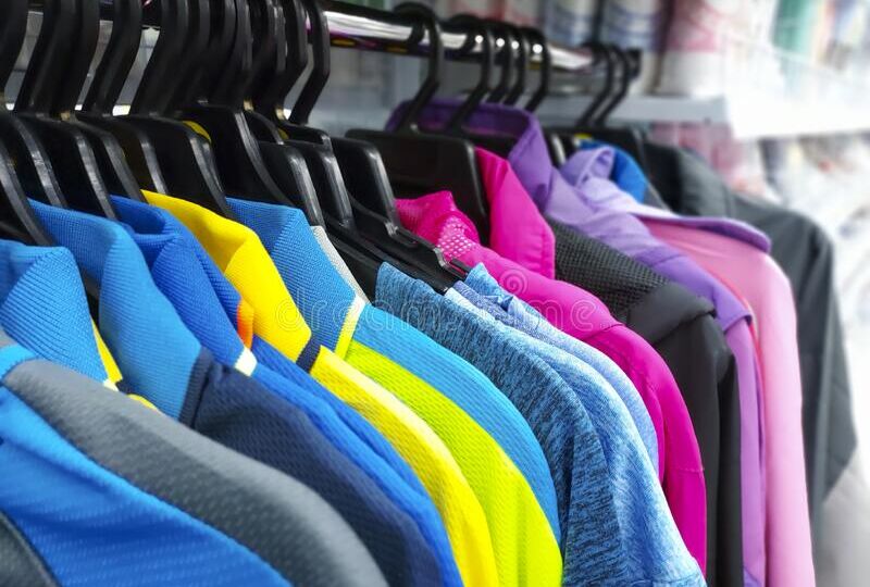 close-up-sports-t-shirts-hanging-hangers-sporting-goods-hypermarket-store-clothes-rack-colorful-coats-hang-252521554